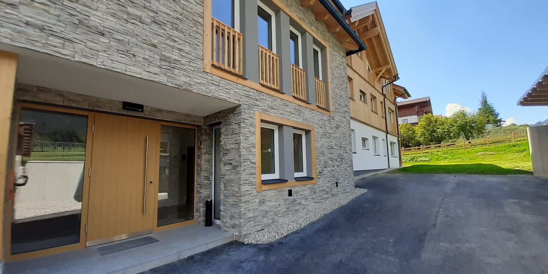 Charakteristische Fassadensteine und hochwertige Granitplatten im Eingangsbereich