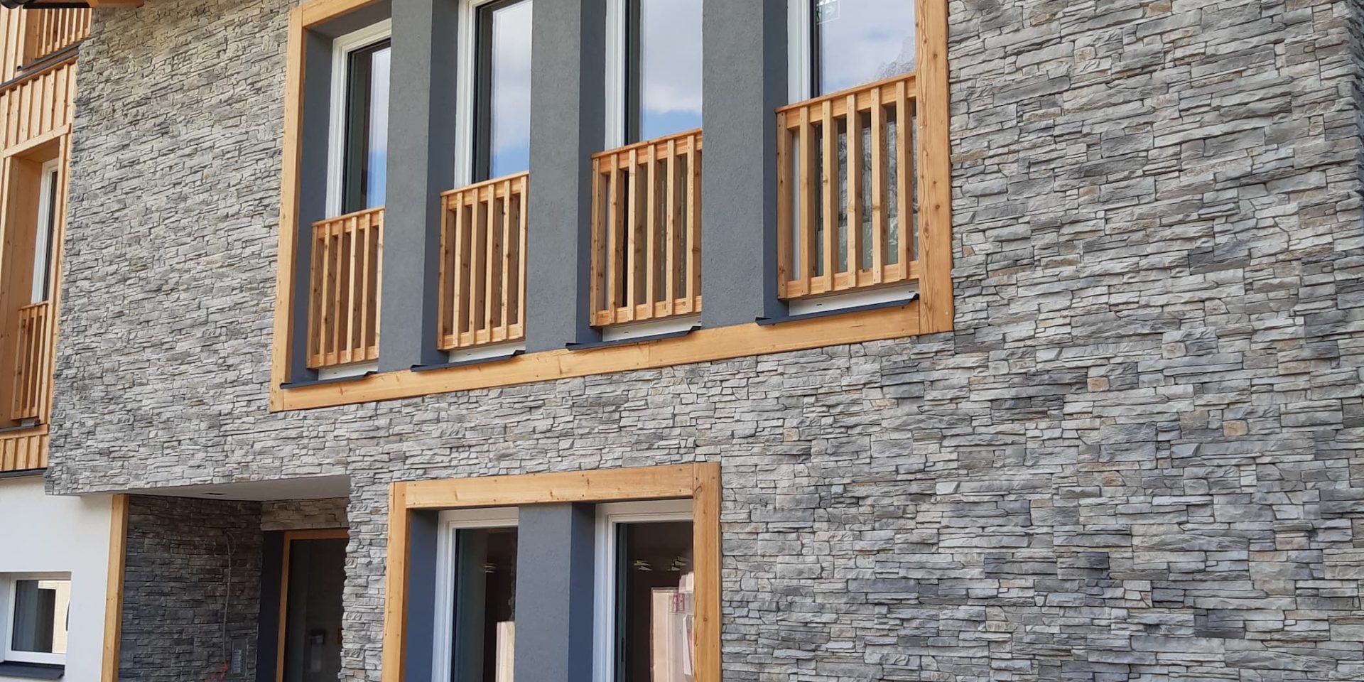 Charakteristische Fassadensteine und hochwertige Granitplatten im Eingangsbereich