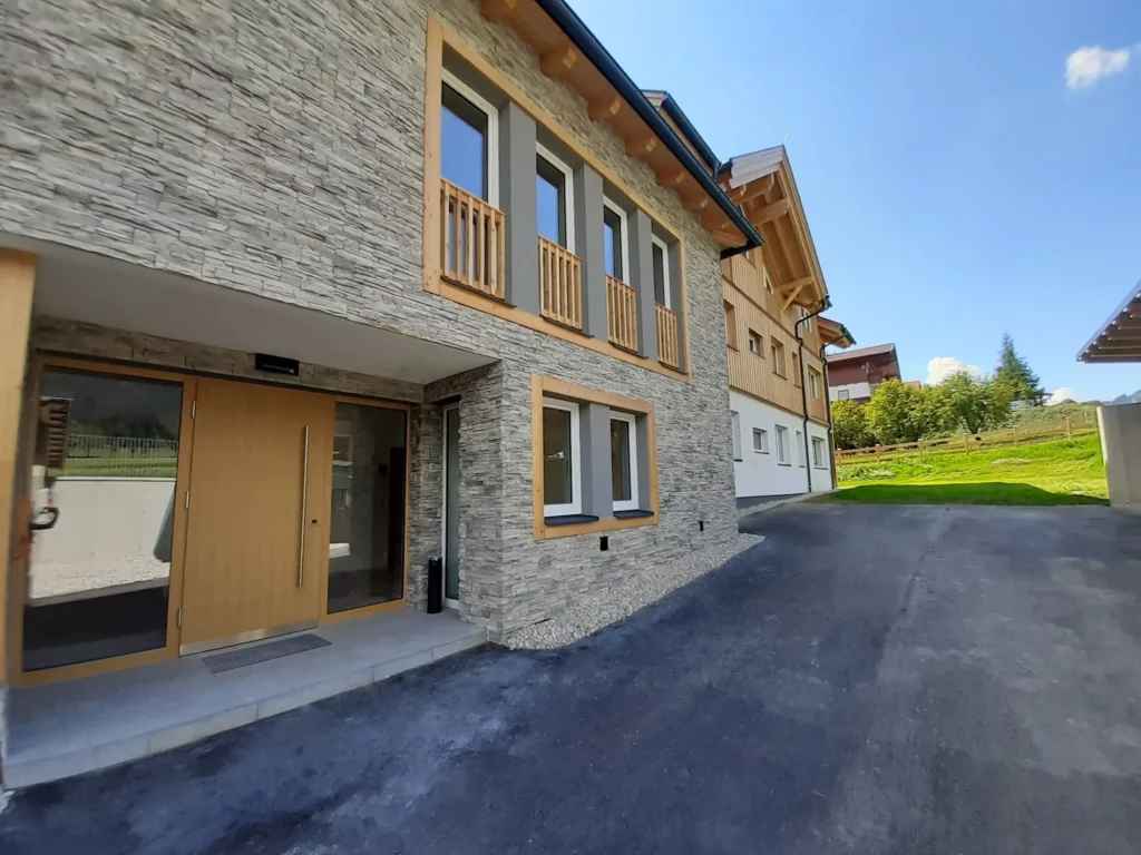 Charakteristische Fassadensteine und hochwertige Granitplatten im Eingangsbereich